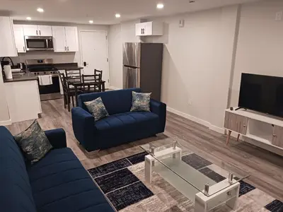 a living room with a blue couch and a kitchen at Fully Furnished Studio Wifi GYM Free Parking in Hartford