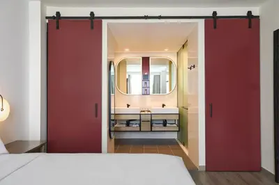 a bedroom with red sliding doors and a bathroom at Renaissance New York Flushing Hotel at Tangram in Queens