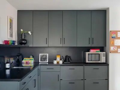 a kitchen with gray cabinets and a microwave at Penny Williamsburg in Brooklyn