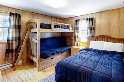 a bedroom with two bunk beds and a bed at Swaying Pines in Wilmington