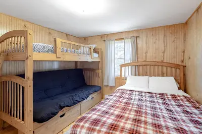 a bedroom with a bed and two bunk beds at Swaying Pines in Wilmington