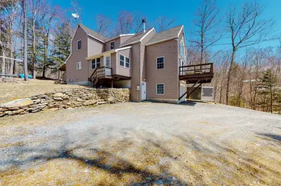 a large house with a stone wall and a driveway at Swaying Pines in Wilmington