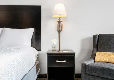 a bedroom with a bed and a lamp and a chair at Hotel One75 in Hamilton