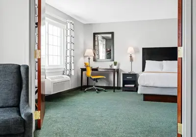a bedroom with a bed and a desk and a chair at Hotel One75 in Hamilton