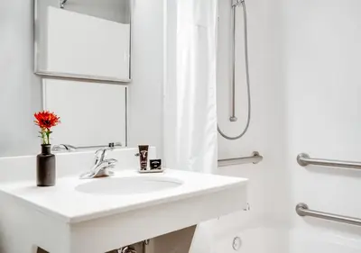 a white bathroom with a sink and a shower at Hotel One75 in Hamilton
