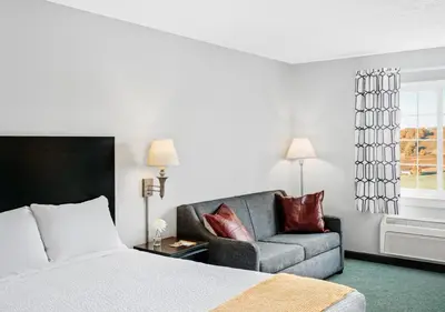 a hotel room with a bed and a couch at Hotel One75 in Hamilton
