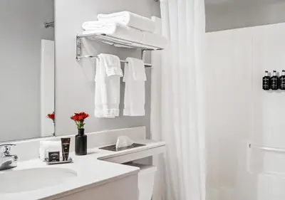 a white bathroom with a sink and a mirror at Hotel One75 in Hamilton