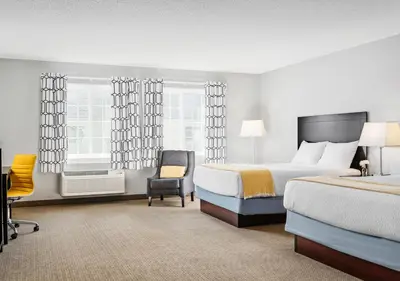 a hotel room with two beds and a chair at Hotel One75 in Hamilton