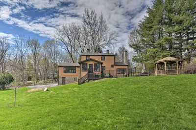 a house on a grassy hill with a gazebo at Lovely Highland Home with Pool and Hot Tub! in Highland