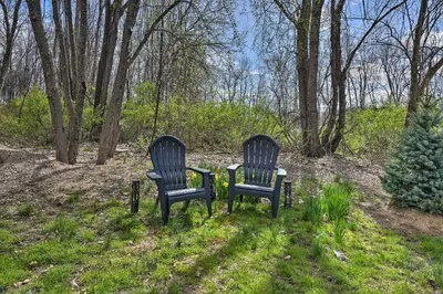 two chairs sitting in the grass near some trees at Lovely Highland Home with Pool and Hot Tub! in Highland