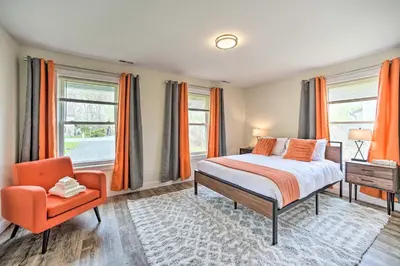 a bedroom with a bed and a chair and windows at Modern-Chic Athens Home - Fish, Ski and Swim! in Athens