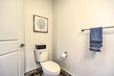 a bathroom with a toilet and a blue towel at Modern-Chic Athens Home - Fish, Ski and Swim! in Athens