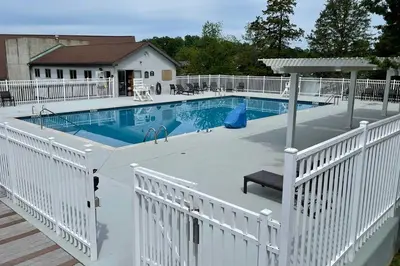 a swimming pool with a white fence around it at Modern-Chic Athens Home - Fish, Ski and Swim! in Athens
