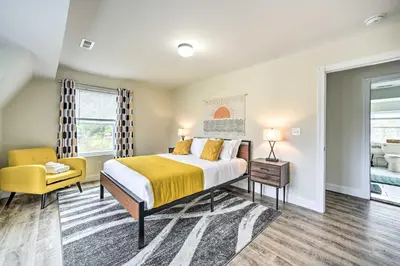 a bedroom with a bed and a yellow chair at Modern-Chic Athens Home - Fish, Ski and Swim! in Athens