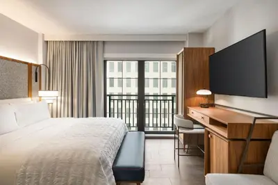 a hotel room with a bed and a desk and a television at Le Meridien New York, Fifth Avenue in New York