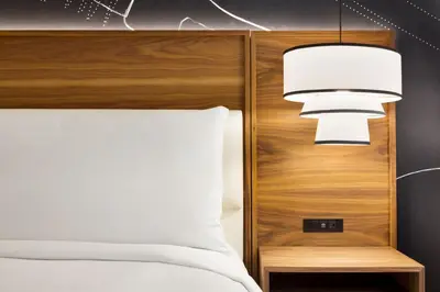 a bedroom with a bed with a wooden headboard at Le Meridien New York, Fifth Avenue in New York