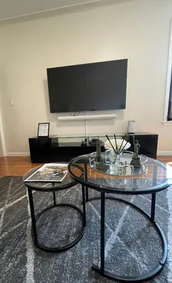 a living room with a glass table and a tv at 1BR Apt in Sunnyside 15 min to Manhattan in Woodside