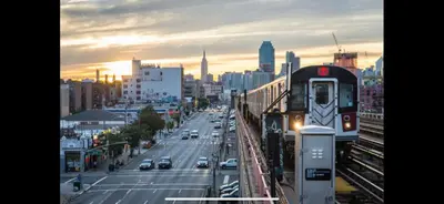a train on a track on a city street at 1BR Apt in Sunnyside 15 min to Manhattan in Woodside