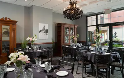 a dining room with tables and chairs and a chandelier at Hotel Anthracite in Carbondale