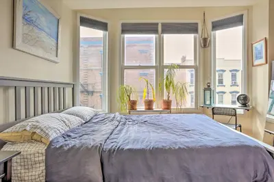 a bedroom with a large bed in front of windows at Hoboken Studio Near Dining about 15 Min to NYC! in Hoboken
