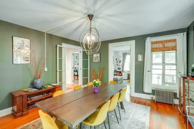 a dining room with a wooden table and yellow chairs at Elegant Pittsfield Home Near Downtown and Skiing! in Pittsfield