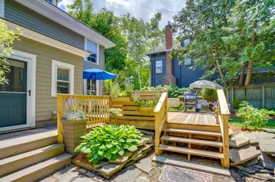 a backyard with a wooden deck and a house at Elegant Pittsfield Home Near Downtown and Skiing! in Pittsfield