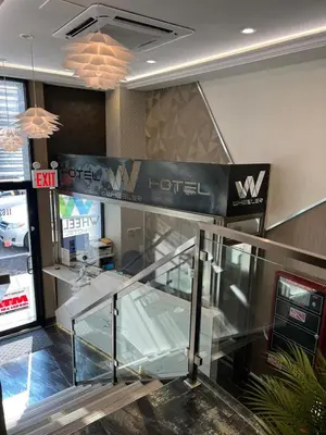 a lobby of a hotel with escalators and a sign at Wheeler Hotel in Bronx
