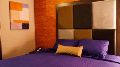 a bedroom with a bed with purple sheets at Wheeler Hotel in Bronx