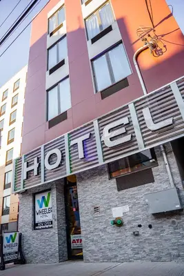 a building with a hotel sign on the front of it at Wheeler Hotel in Bronx