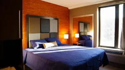 a bedroom with a bed with a blue comforter at Wheeler Hotel in Bronx
