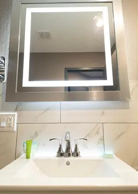 a bathroom sink with a large mirror above it at Wheeler Hotel in Bronx