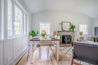 a living room with a table and a fireplace at Beautiful Charming Cottage 4 min from Woodstock in Woodstock