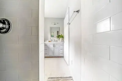 a white bathroom with a shower and a sink at Beautiful Charming Cottage 4 min from Woodstock in Woodstock