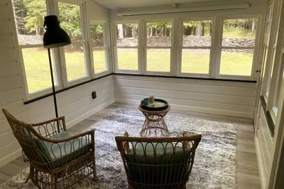 a room with two chairs and a table and windows at Beautiful Charming Cottage 4 min from Woodstock in Woodstock