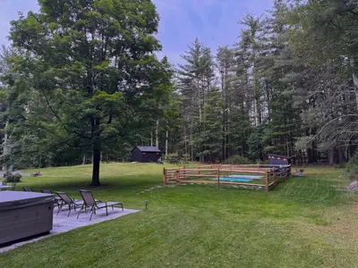 a backyard with a picnic table and chairs and a fence at Beautiful Charming Cottage 4 min from Woodstock in Woodstock