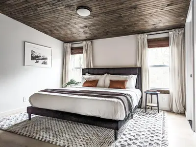 a bedroom with a large bed with a wooden ceiling at Pinewood Bungalow - Luxury Cabin, Kid-Friendly in Catskill