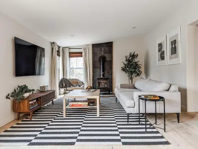 a living room with a couch and a table at Pinewood Bungalow - Luxury Cabin, Kid-Friendly in Catskill