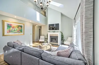 a living room with a large couch and a fireplace at Family-Friendly Retreat with Hot Tub 1 Mi to Dtwn in Saratoga Springs