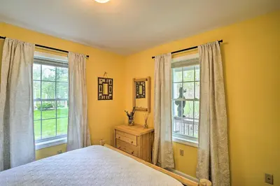 a bedroom with yellow walls and two windows and a bed at Family-Friendly Hancock Home Walk to Slopes! in Hancock