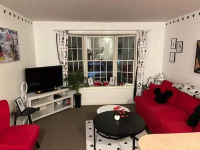 a living room with a red couch and a tv at Disney Magic at Jiminy Mountain in Hancock