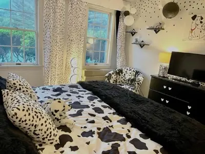 a bedroom with a cow patterned bed and a television at Disney Magic at Jiminy Mountain in Hancock