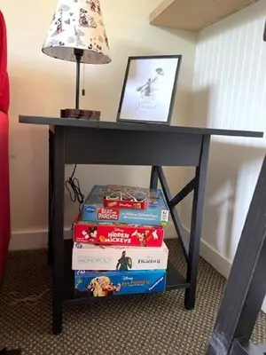 a pile of books under a table with a lamp at Disney Magic at Jiminy Mountain in Hancock