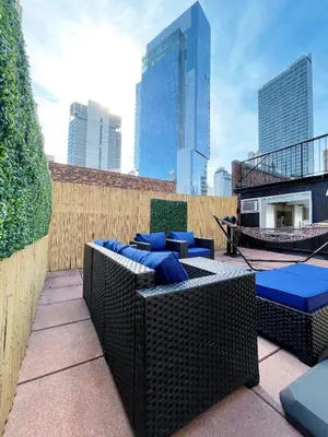 a rooftop patio with blue chairs and a fence at Hotel and the City, Rooftop City View in New York