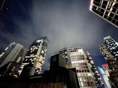 a group of tall buildings in a city at night at Hotel and the City, Rooftop City View in New York