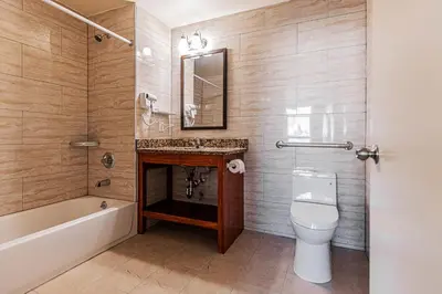 a bathroom with a toilet and a sink and a tub at Astoria Inn LaGuardia Hotel in Queens