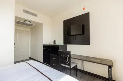 a hotel room with a desk and a tv at Astoria Inn LaGuardia Hotel in Queens