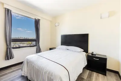 a bedroom with a bed and a large window at Astoria Inn LaGuardia Hotel in Queens