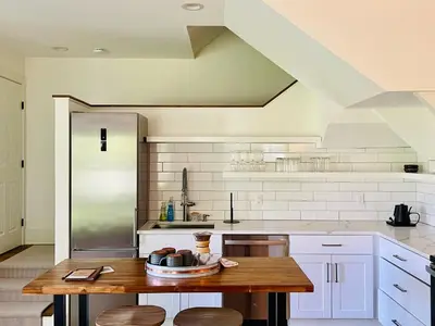 a kitchen with a wooden table and white cabinets at Hill Farm Inn - Manchester in Sunderland