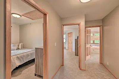 a bedroom with a bed and a mirror at Lakefront Gloversville Home with Beach and Dock! in Broadalbin
