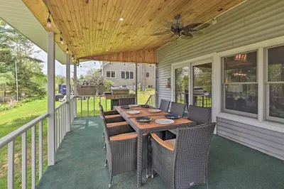 a patio with a table and chairs on a porch at Lakefront Gloversville Home with Beach and Dock! in Broadalbin
